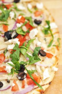 Greek Chicken Pizza Recipe as made by using leftover chicken, remaining feta, and a few remaining olives from a can to make this pizza. Ole!